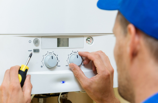 Tradesman fixing a boiler