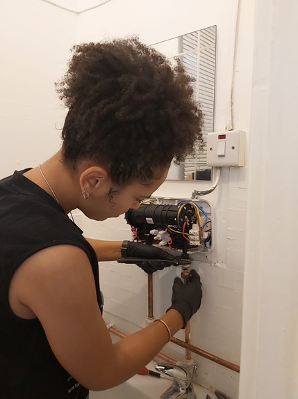 Leah training for her new career as a plumber